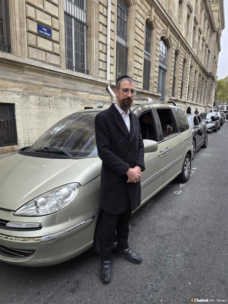 Rabbi Moyche Cohen stands next to his car that was smashed and burnt during the protests in Paris this past weekend.