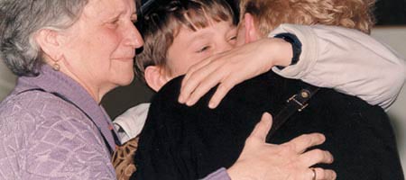 A child hugs his mother, with his grandmother looking on, prior to leaving Ukraine to Israel to be cared for by Chabad&#39;s Children of Chernobyl. Close to 80% of the children have been reunited in Israel with their family.