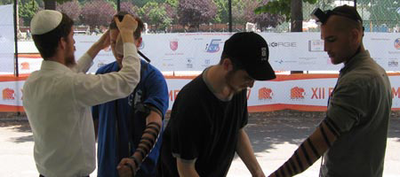 Chabad-Lubavitch rabbinical students assist athletes to don tefillin at the Maccabi games