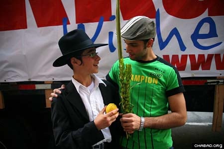 A passing New Yorker thanks a Chabad-Lubavitch rabbinical student for giving him to opportunity to make the blessing on the lulav and etrog. (Photos: Meir Alfasi)