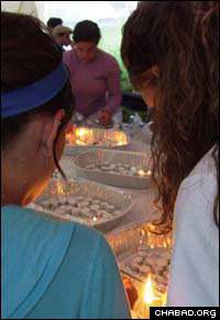 College girls mark the onset of Shabbat by lighting candles.