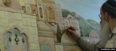 Michoel Muchnik, a Lubavitch Chasid and artist, adds some color to one of his paintings.