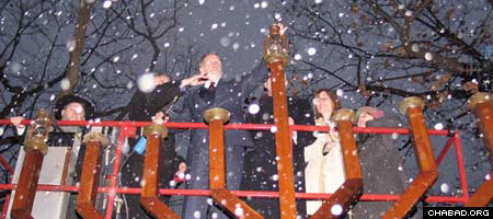 In falling snow, New Jersey Gov. Jon Corzine, center, helps light the Chanukah menorah sponsored by the Rabbinical College of America, a Chabad-Lubavitch yeshiva in Morristown, N.J.