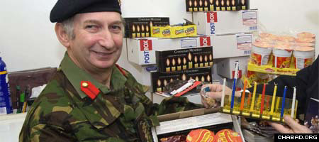British Army Col. Martin Newman receives menorahs and gift packages for Chanukah from Chabad-Lubavitch of Manchester in England. (Photo: Mike Poloway)