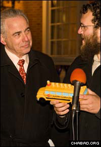 Rabbi Dovid Tiechtel, right, co-director of the Chabad Center for Jewish Life at the University of Illinois at Urbana-Champaign, presents a menorah in the shape of a school bus to the university’s chancellor Richard Herman.
