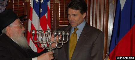 Rabbi Shimon Lazaroff, left, director of Chabad-Lubavitch of Texas, presents Gov. Rick Perry with an inscribed silver menorah.