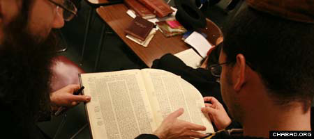 With a little bit of guidance, a visitor, right, to the Rabbinical College of America, studies a page from the Talmud. (Photos: Y. Moully)