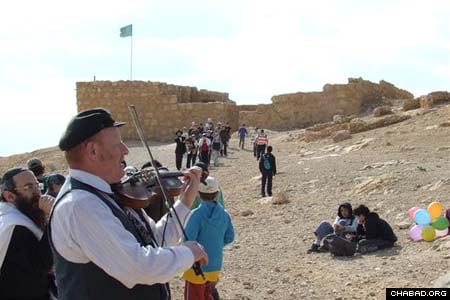 A violinist sets the mood for a mass bar and bat mitzvah celebration organized by Chabad-Lubavitch of Ramat Hasharon, Israel, for some 600 of the town’s seventh-graders. The ceremony took place atop the country’s mountaintop fortress of Masada.