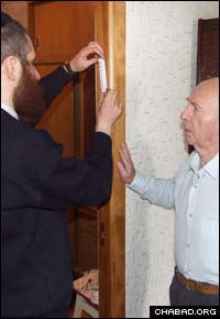 A Chabad-Lubavitch rabbi affixes a mezuzah to the doorpost of a home in Dnepropetrovsk, Ukraine.