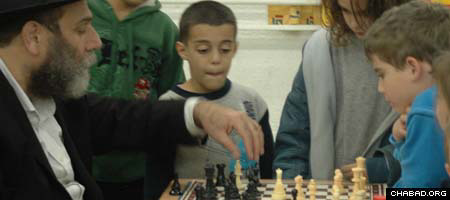 Israeli chess champion Dov Zaltz, left, teaches schoolchildren about the intricacies of the classic board game. (Photo: Yaron Skajio)