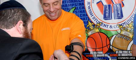 Rabbi Berl Goldman, co-director of the Lubavitch-Chabad Jewish Student &amp; Community Center serving the University of Florida, helps University of Tennessee basketball coach Bruch Pearl lay tefillin.