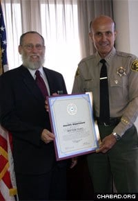 Rabbi Bentzion Kravitz, a volunteer police chaplain, receives an award from the Los Angeles Sheriff’s Department.