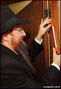 Chabad-Lubavitch Rabbi Berel Lazar, chief rabbi of Russia, affixes a mezuzah to the new Kiryat Hasofrim, an interactive museum and scribal arts factory in Safed, Israel.