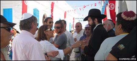 Chabad-Lubavitch Rabbi Schneor Hadad meets with some of the thousands of Jews who visited the famed El Ghriba Synagogue in Tunisia this year.