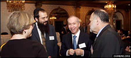 Chabad-Lubavitch Rabbi Shalom Lubin, second from left, and New Jersey Supreme Court Justice Barry T. Albin, talk with attendees at the second-annual Jewish Law Symposium.