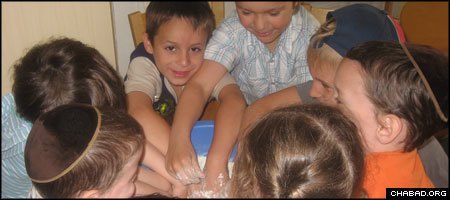Jewish children in Tallin, Estonia, busy themselves with making challah during a session of the local Camp Gan Israel.