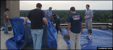 Jewish students from Texas A&amp;M University affix tarp to a damaged roof at a Houston senior home. The project was arranged by their campus-based Chabad House.