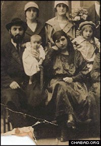 Rabbi Avraham Baruch, seen holding young Sholom Ber, and Alte Pevzner moved to Minsk at the behest of the Sixth Chabad Rebbe. Hillel Pevzner stands at the right.