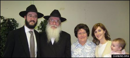 Rabbi Moshe Katsenelenbogen, second from left, rescued a Torah scroll from a synagogue destroyed by Soviet authorities decades ago. Standing with him are his wife Zelda, and his son and daughter-in-law, Rabbi Nochum and Chanie Katsenelenbogen.