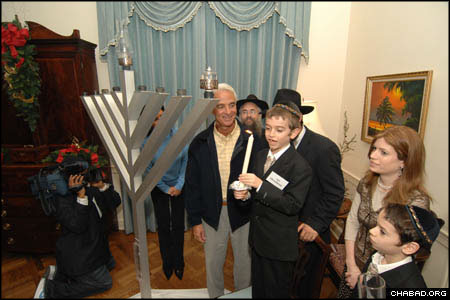 Ari Oirechman, 8, lights the Chanukah menorah at the Florida state capitol in Tallahassee as his mother Chanie Oirechman, co-director of Chabad-Lubavitch of Tallahassee, looks on.
