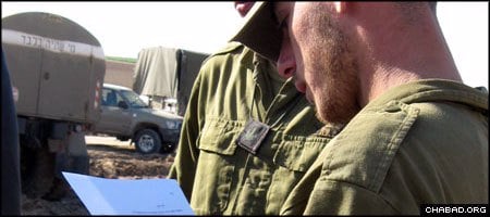 An Israeli soldier reads a letter of encouragement, one of thousands written by people all over the world through a project spearheaded by Chabad.org. (Photo: Elad Nehorai)
