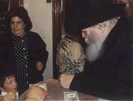 Four year old Amo receiving a dollar from the Lubavitcher Rebbe, Rabbi Menachem Mendel Schneerson, of righteous memory.