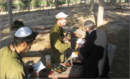 הרב בוטמן, מבית חב"ד רמת השרון, מניח תפילין לחיילים