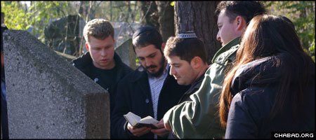 Assisted by Rabbi Daniel Ash, Misha Gorbunov prays at the gravesite of his ancestor in Bobruisk, Belarus.