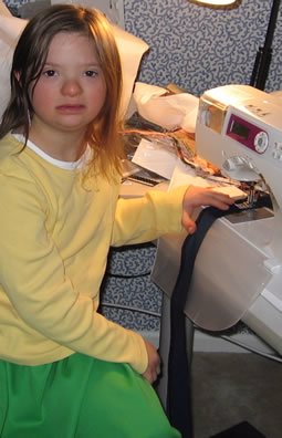 Gavriella with her sewing machine. She has a special one that can be adjusted to sew slowly and she has sewn several garments.
