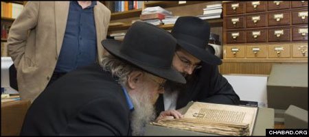 Rabbi Adin Even Yisroel Steinsaltz, center, peruses a rare Jewish manuscript housed in Oxford University’s famed Bodleian Library. (Photo: Frederic Aranda)
