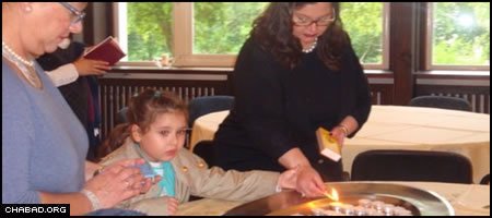 Attendees light candles in advance of Shabbat at a Jewish retreat in Liebenwalde, Germany.