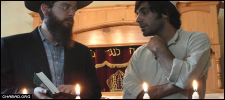 Rabbi Yehuda Kirsch and a former Israeli soldier participate in a memorial ceremony at the Chabad House in Manali, India, for fallen members of the Golani 51st.