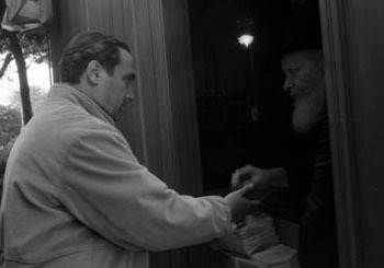 The Rebbe distributes honey cake, Lekach, on Hoshannah Rabbah (Photo: Levi Freidin/JEM)