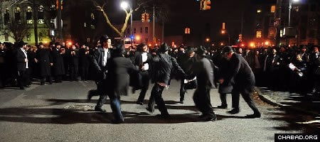 Chabad-Lubavitch emissaries dance at the intersection of Eastern Parkway and Brooklyn Avenue in Brooklyn, N.Y., Thursday night after joining in the completion of a Torah scroll in memory of Rabbi Gavriel and Rivka Holtzberg, the slain directors of the Mumbai, India, Chabad House. (Photo: Boruch Ezagui)