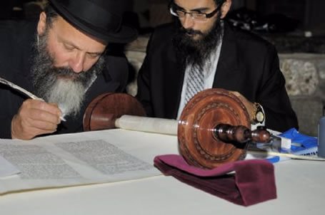 Rabbi Nachman Holtzberg, father of Gabi, fills in one of the final letters in the Litchfield Torah.