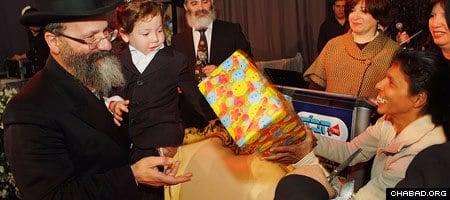 Indian nanny Sandra Samuel presents three-year-old Moshe Holtzberg, whom she saved from the carnage of Mumbai’s Chabad House, with his birthday present.