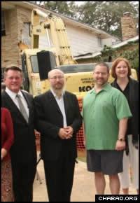 Rabbi Chaim Block stands with community members as the demolition gets underway.