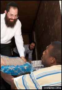 L'émissaire 'Habad-Loubavitch Rav Shimon Pelman distribue des vivres à des survivants du tremblement de terre. (Photo: Marc Asnin/Chabad.org)