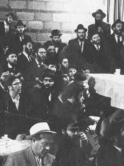 At a farbrengen with the Rebbe during this trip, I can be seen in the foreground wearing a white hat.