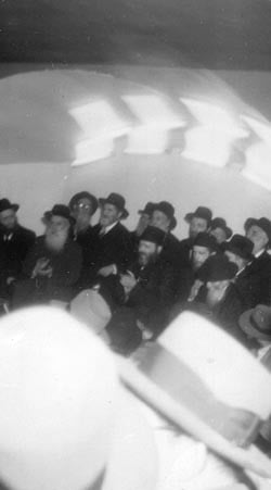 The Rebbe standing, clapping and dancing during the Yud Tes Kislev farbrengen 5715 (1955)