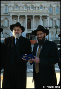 Rabbis Shmuel Kaplan and Zev Gopin stand outside City Hall with the ceremonial key to the city of Baltimore.