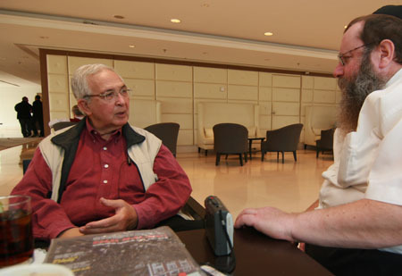 Yitzchak Yehudah Holtzman listens as Dan Patir describes his visits at Lubavitch World Headquaters. (Photo: Kfar Chabad Magazine)