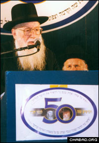 Rabbi Menachem Porush addresses attendees of a celebration marking the 50th anniversary of the founding of Kfar Chabad, Israel.