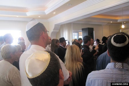 Congregants at Chabad-Lubavitch of North Cyprus in Kyrenia stand as the center’s new Torah scroll is readied for its dedication.
