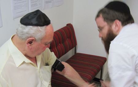 Wrapping tefillin on an elderly gentleman in the JCC.
