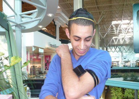 One of the Israelis in the mall putting on tefillin.