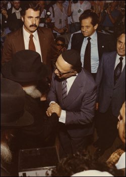 Prime Minister Begin bids farewell to the Rebbe, of righteous memory. Yehudah Avner is standing on the right of the Prime Minister. (Photo: Velvel Schildkraut (Michele) Studios/Kahn family)