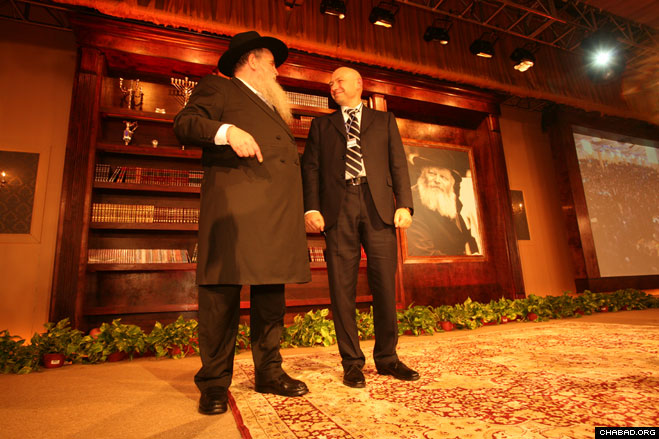 Rabbi Moshe Kotlarsky, director of the International Conference of Chabad-Lubavitch Emissaries and vice chairman of Merkos L’Inyonei Chinuch, the educational arm of Chabad-Lubavitch, and Ukraine billionaire philanthropist Gennady Bogolubov glance at a banquet-hall full of 4,500 dancing guests at the 27th annual conference’s gala banquet Sunday night.
