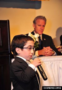 Shmuly Brafman, a student at the elementary school affiliated with the Rabbinical College of America in Morristown, N.J., entertains the crowd at the institution’s 40th anniversary dinner as Israeli Ambassador Michael B. Oren listens to the performance. (Photo: Michael Livshin)