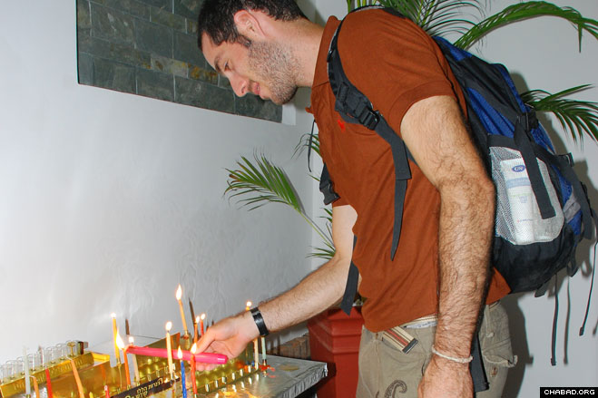 A visiting Israeli in Saigon lights an individual Chanukah menorah at Chabad-Lubavitch of Vietnam.